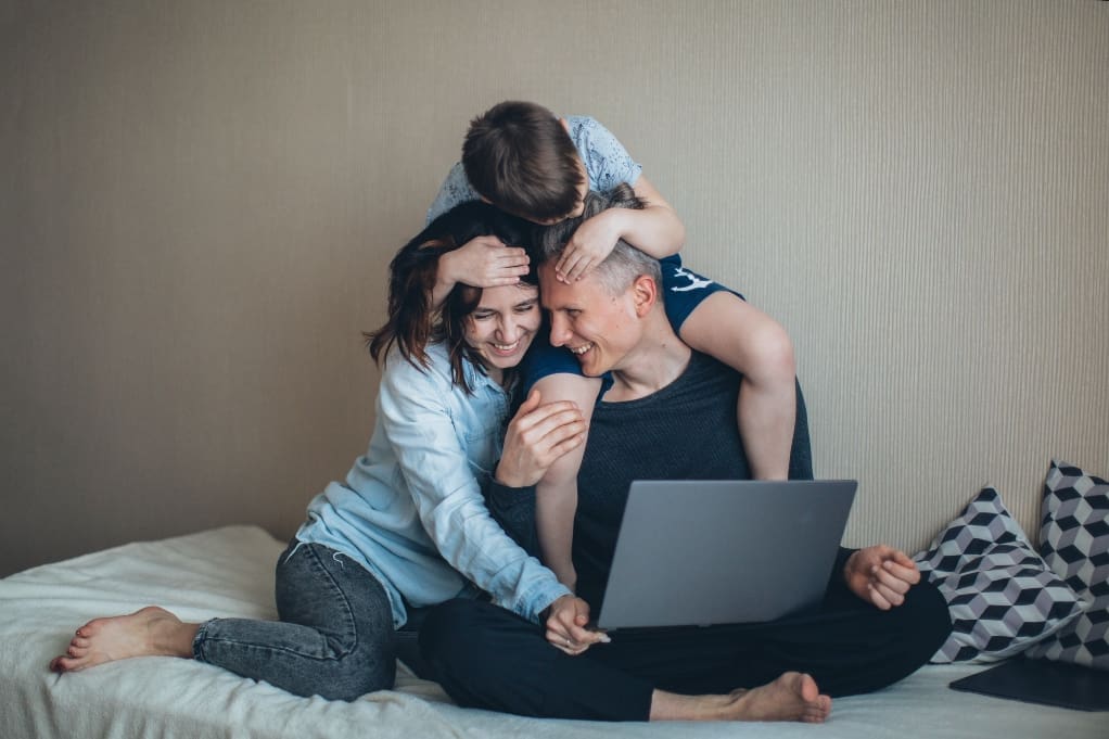 Father, mother, and son looking at a computer and spending time as a family.